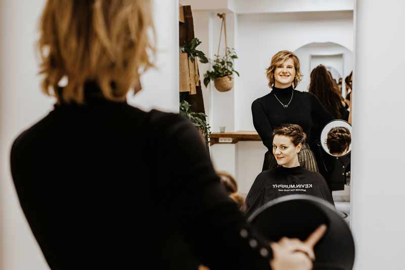 Im Rostocker Friseursalon wird der Kundin das Ergebnis im Spiegel präsentiert.