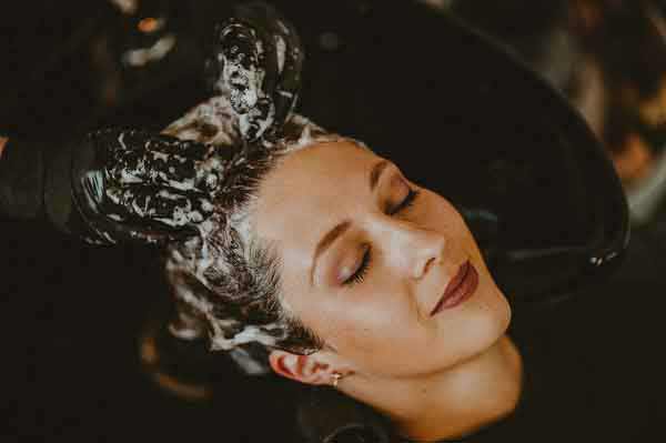 entspannte Frau beim Haare waschen